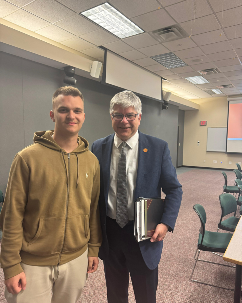 American Academy of Technology university student Klajdi Spahiu posing in a photo with RIT NY president William H Sanders.