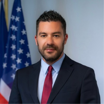A professional photo of Krenar Kepuska with a US flag in the background